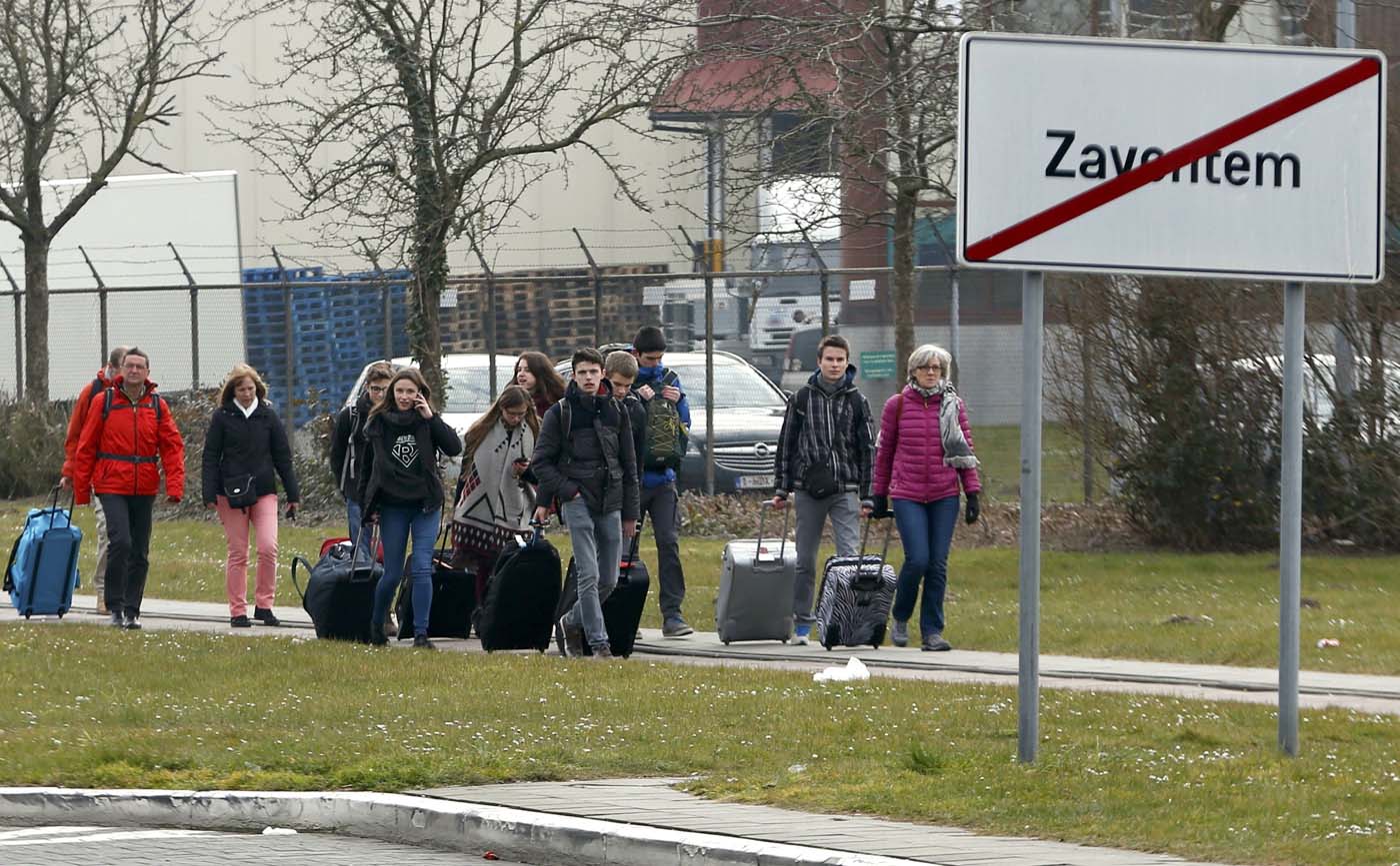 People leave the scene of explosions at Zaventem airport near Brussels, Belgium