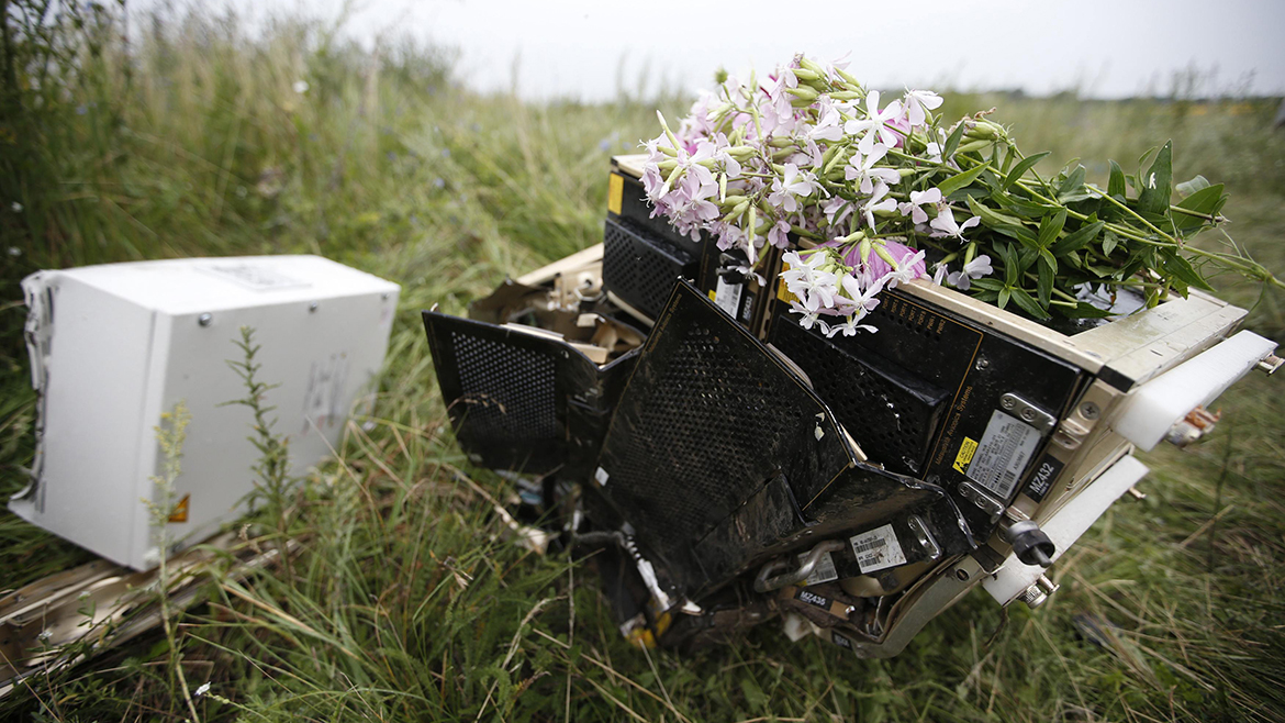 Flowers lie on debris from a Malaysian Airlines Boeing 777 plane which was downed on Thursday near the village of Rozsypne