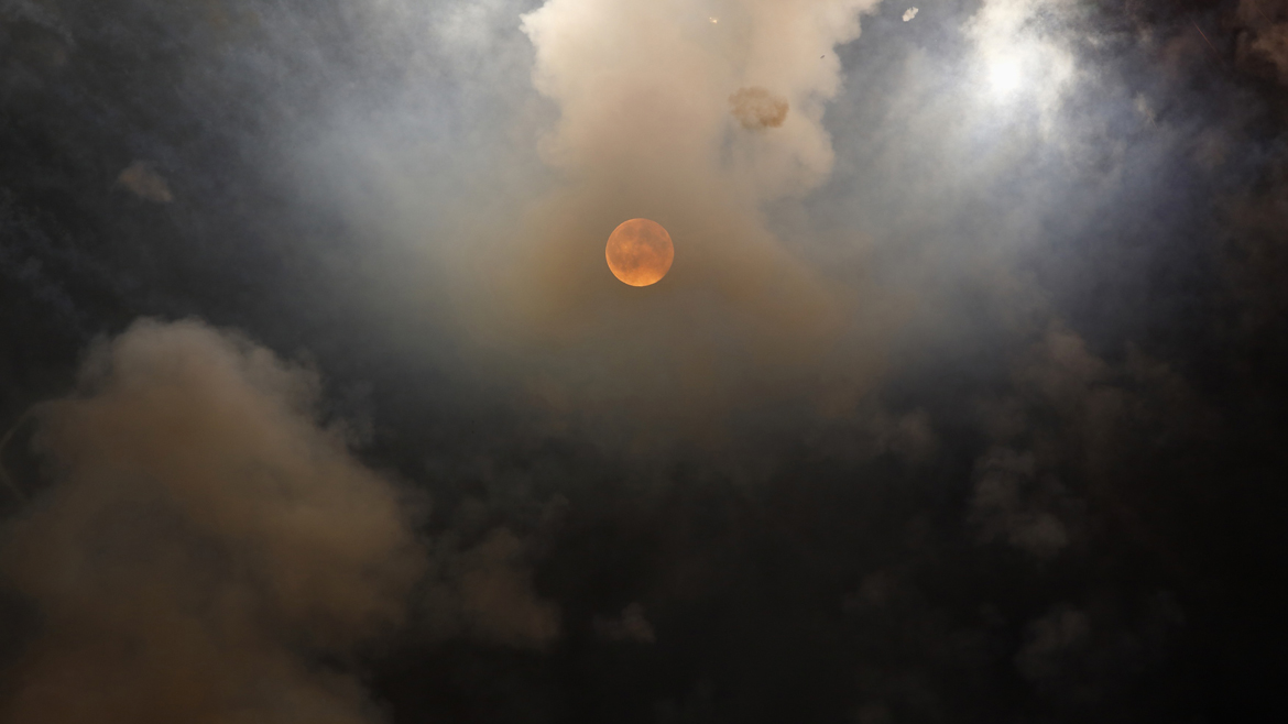 Smoke from fireworks partly obscures the supermoon outside the town of Mosta, celebrating the feast of its patron saint, in central Malta