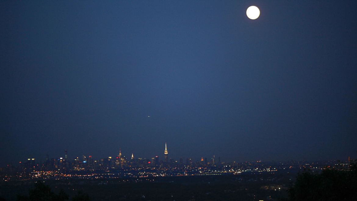 A full moon known as a "supermoon" rises over the skyline of New York and the Empire State Building, as seen from the Eagle Rock Reservation in West Orange, New Jersey