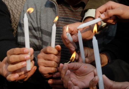 Personas encienden velas en memoria de las víctimas del ataque talibán en una escuela pública en Peshawar