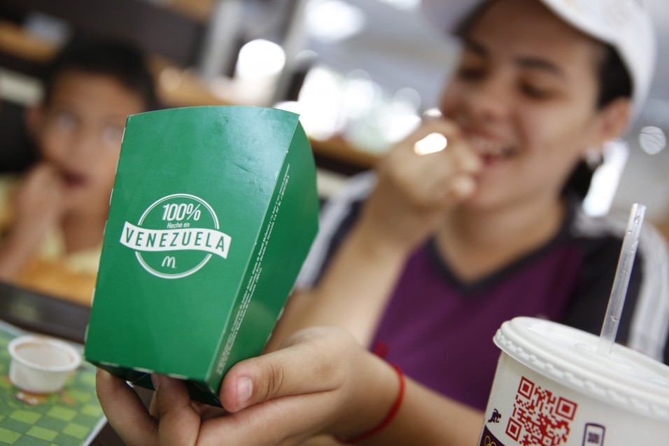 A girl eats deep-fried yucas at a McDonald's restaurant in Caracas