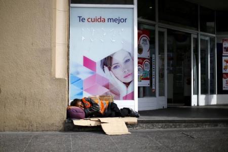 Una persona durmiendo a las afueras de una farmacia en el centro de Santiago