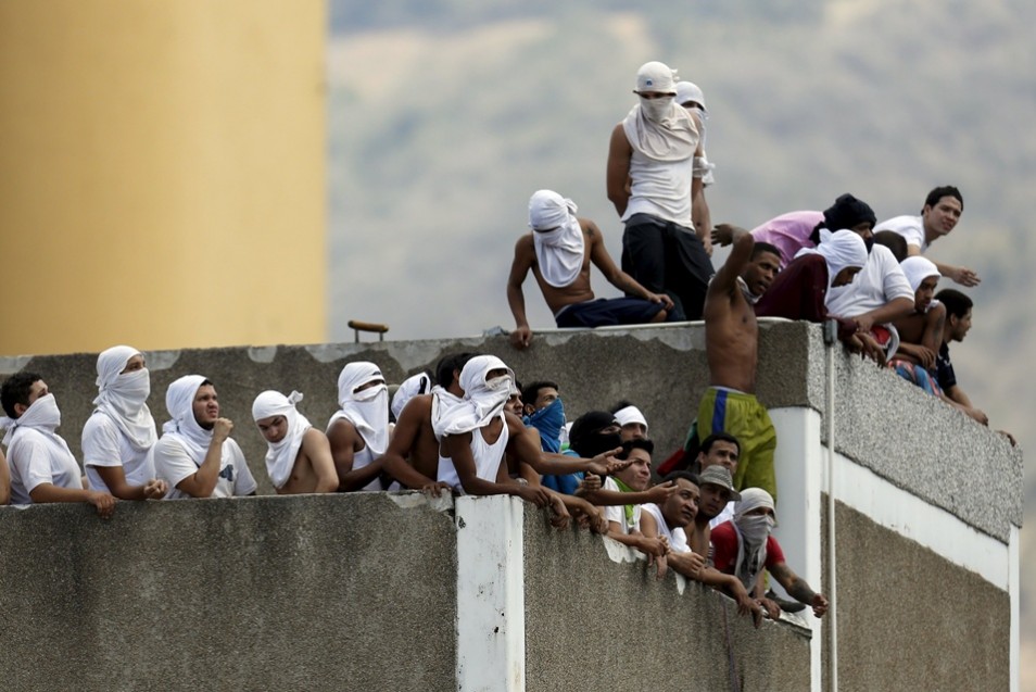 Inmates gather on the roof of the prison of the National Bolivarian Police during a riot in Caracas