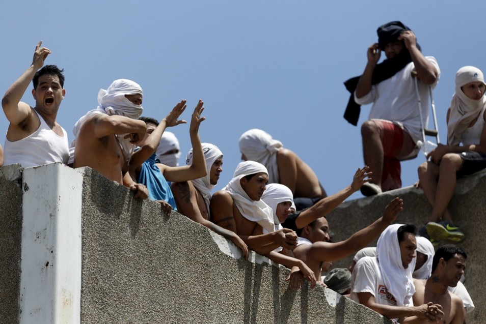 Inmates gather on the roof of the prison of the National Bolivarian Police during a riot in Caracas