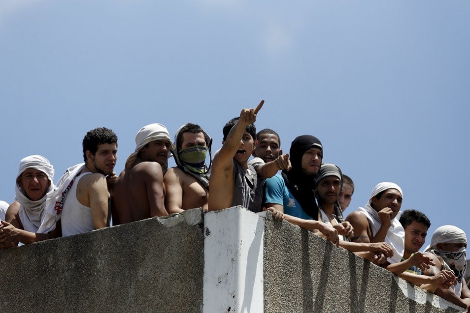 Inmates gather on the roof of the prison of the National Bolivarian Police during a riot in Caracas,