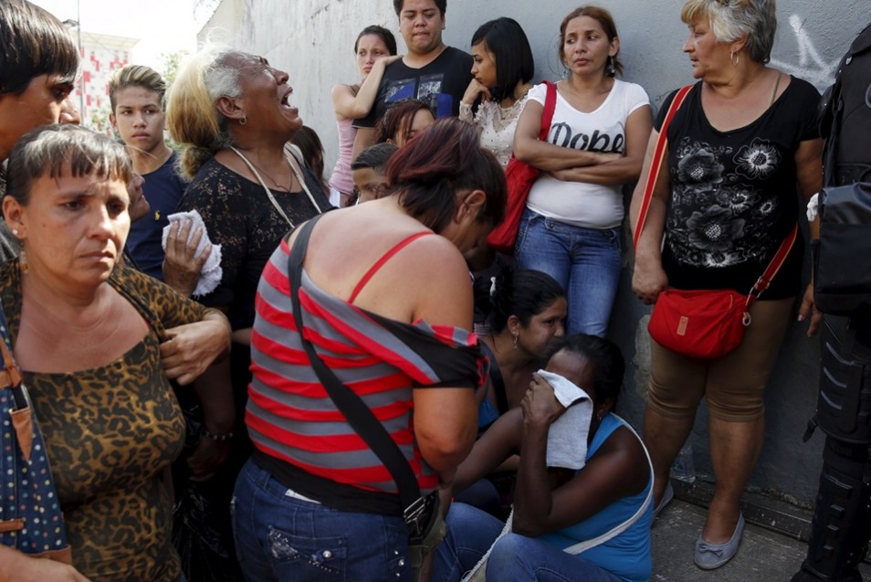 Relatives of inmates react outside the National Bolivarian Police prison, during a prison riot in Caracas