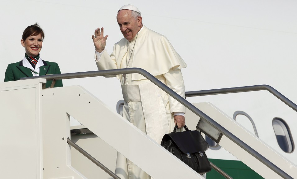 Francis waves as he boards a plane for his pastoral trip, at Fiumicino airport in Rome